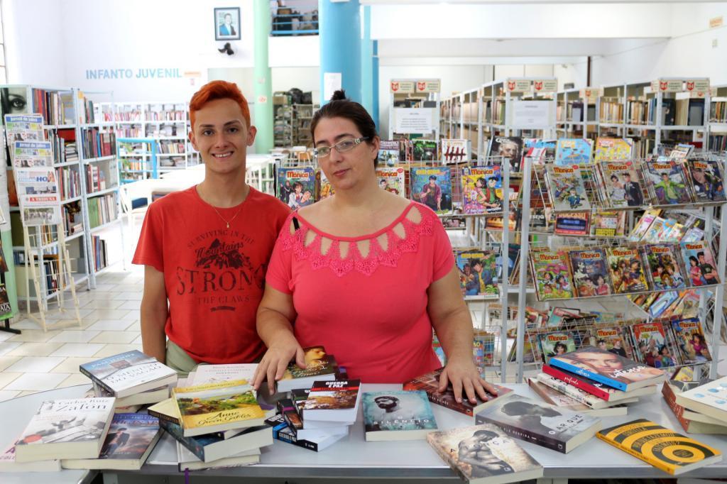A responsável pela Biblioteca Municipal, Carla Fontana e o estagiário Higor Gustavo, mostram os novos lançamentos de livros adquiridos