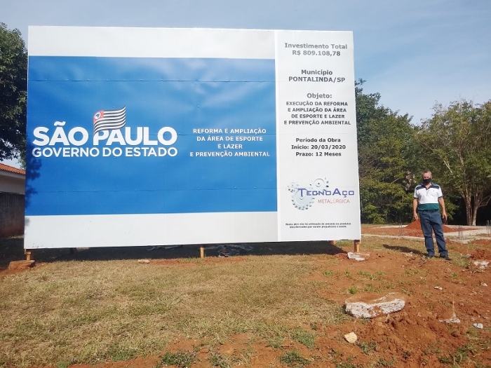 Prefeito Elvis ao lado da placa de Investimento da obra