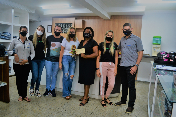 A ganhadora Admar recebendo das equipes da ACIJ e da Twister Modas, o vale-compras de R$ 10 mil