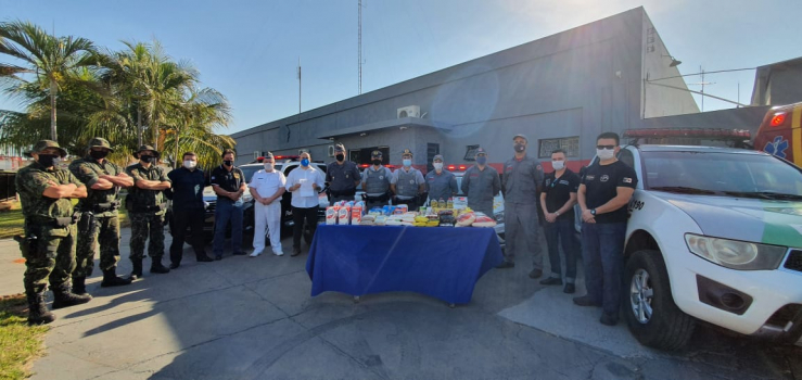 Profissionais da área de segurança doam alimentos durante a imunização contra a Covid-19