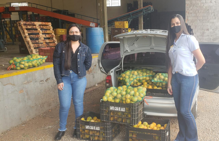 O Setor de Captação de Recursos recebendo a doação das caixas de tangerina ao lado da colaboradora Águida Santos, da empresa Frutas Ternero